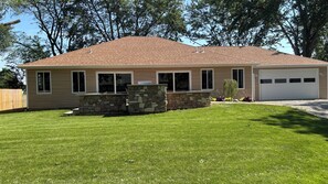 A single-story house with a stone foundation, a garage, and a well-maintained lawn. - Rusty’s Getaway is a rustic/modern handicap accessible, family friendly space.  (Findlay)