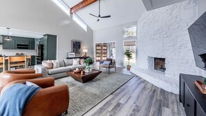 A spacious living room with a stone fireplace, a sofa set, and a coffee table.