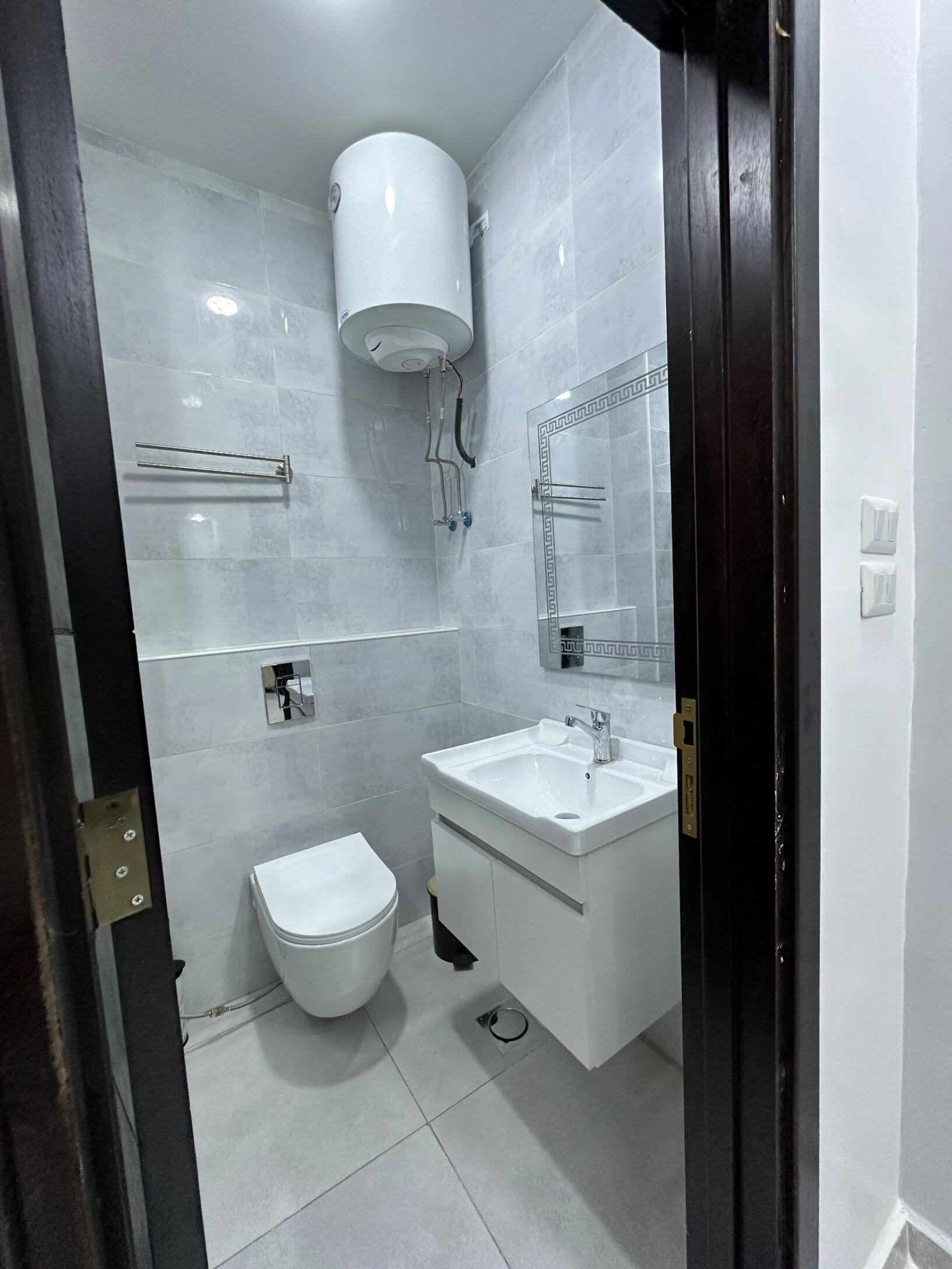 A modern bathroom with a toilet, sink, and shower.