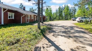 A red building with a gravel driveway and parked cars. - Urupää b 6 by Interhome (Inari)