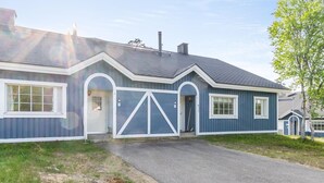 Une maison de plain-pied à l’extérieur bleu foncé, avec des boiseries blanches et un toit gris.