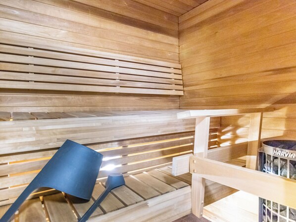 A sauna room with wooden benches and a bench with a nameplate.
