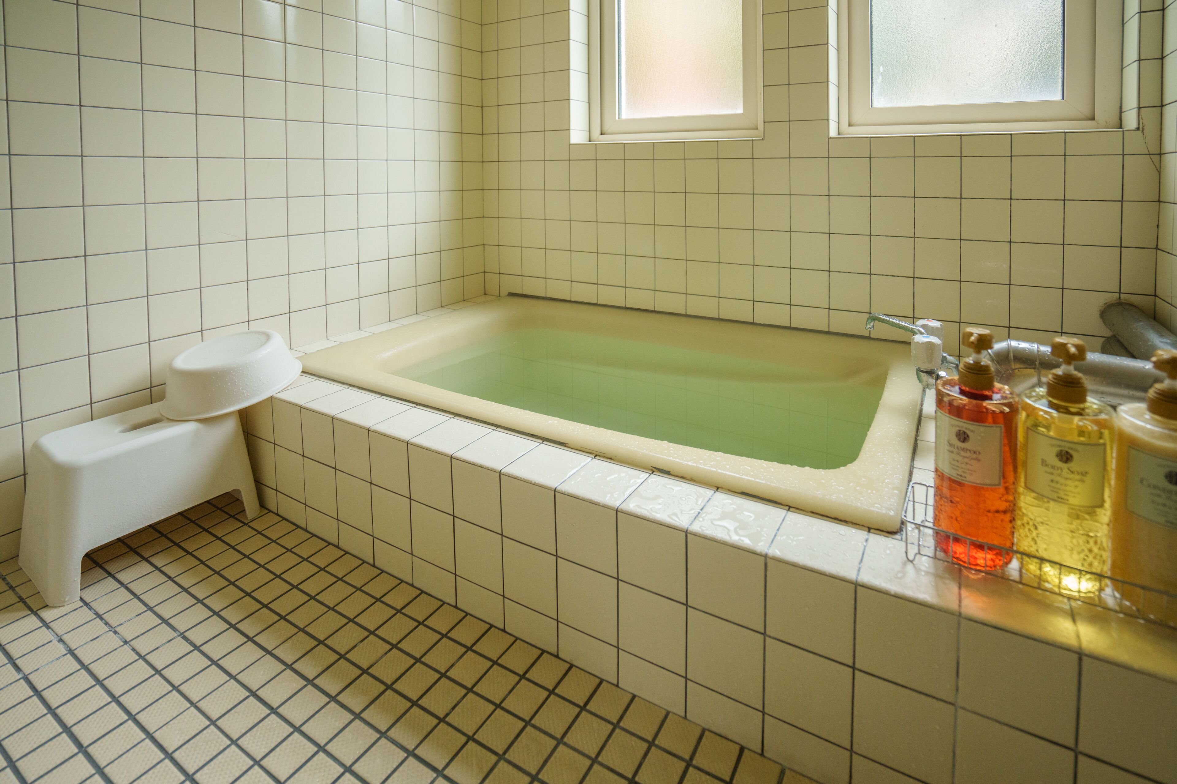 A bathroom with a bathtub, a toilet, and a window.