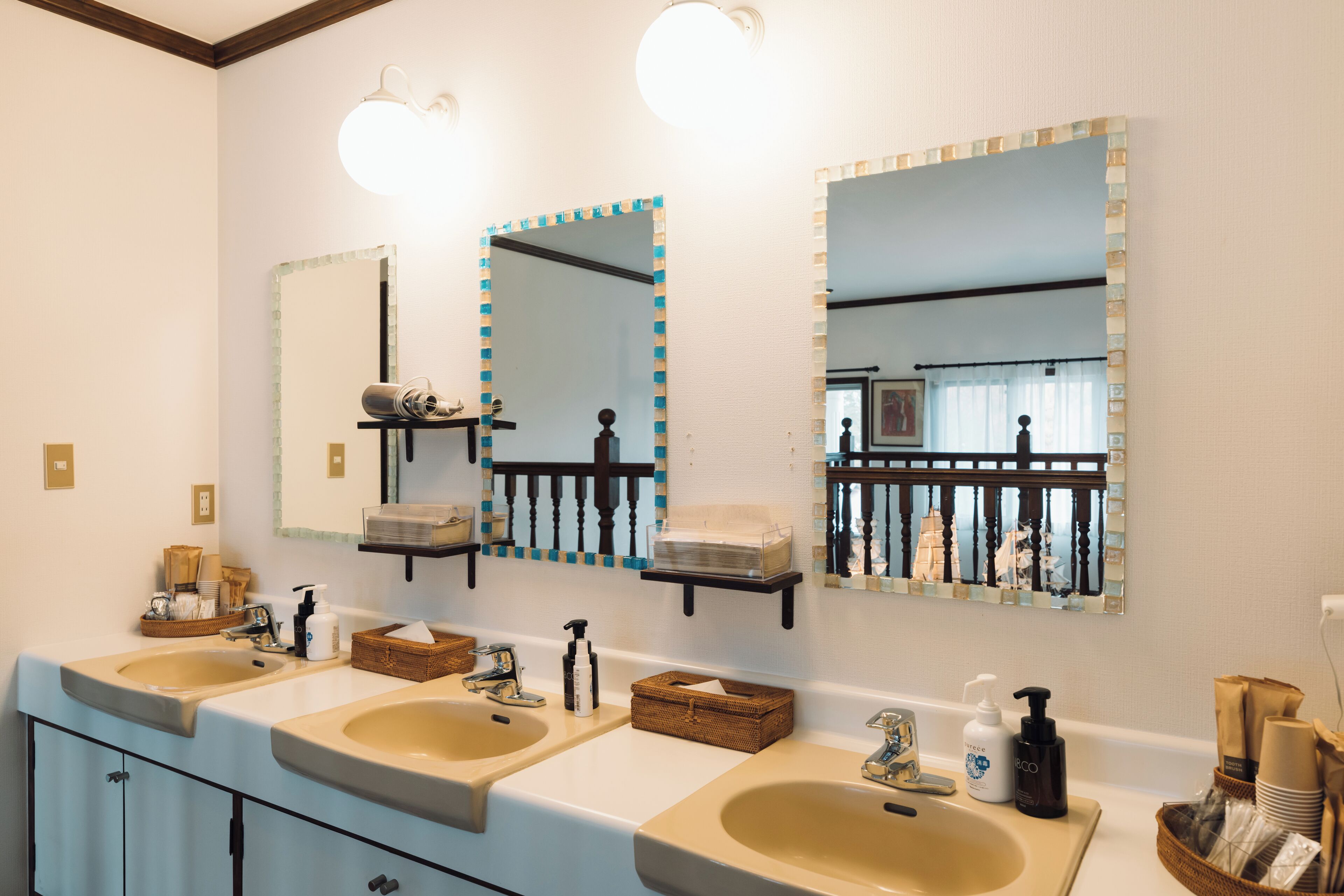 A bathroom with two sinks, a mirror, and shelves with toiletries.