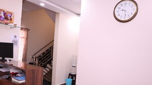 A reception desk with a computer monitor, a blue trash bin, and a water dispenser. - Smilestay Karanji Paradise (Bengaluru)
