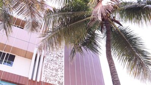 A building with a sign for 'KARANJI PARADISE' and 'Liquor Station Restaurant'. - Smilestay Karanji Paradise (Bengaluru)