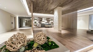 A spacious lobby with a wooden floor, a central seating area, and a decorative plant arrangement. - Romantic-Paradise-Luxurious-5 star-1BR-OceanFront-View-Balcony-Miami-South-Beach (Miami Beach)