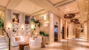 A spacious lobby with a wooden floor, white sofas, and a staircase leading to an upper level. - Romantic-Paradise-Luxurious-5 star-1BR-OceanFront-View-Balcony-Miami-South-Beach (Miami Beach)