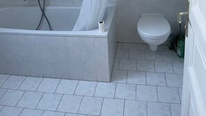 A bathroom with a bathtub, shower, and toilet. - Gemütliche Wohnung in Berlin Mitte (Berlin)