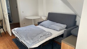 A compact bedroom with a bed, a small table, and a chair. - Gemütliche Wohnung in Berlin Mitte (Berlin)