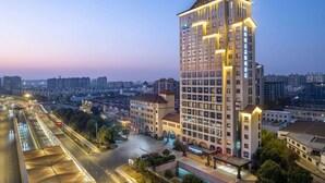 Un hôtel de grande hauteur, avec de nombreux étages, un hall d’entrée bien éclairé et un espace de stationnement.