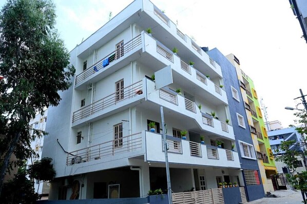 A multi-story residential building with balconies, a flat roof, and a modern architectural design.