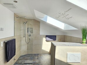 A modern bathroom with a shower, a towel rack, and a skylight. - Neueröffnung "der Tegernsee Stern" (Rottach-Egern)
