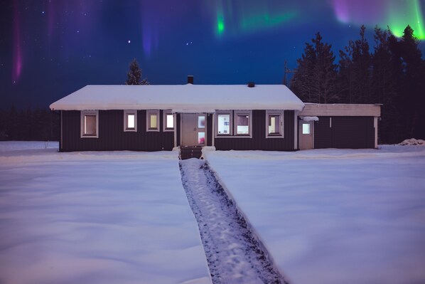 A two-story building with a snow-covered roof and a central entrance. - SBC Guesthouse (Pajala)