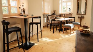 Un comedor con mesa de madera, sillas negras y un sofá antiguo.