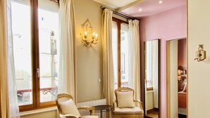 A room with two upholstered chairs, a small table, and a chandelier. - CamParis - B&B - Chambre d'hôtes (Paris)