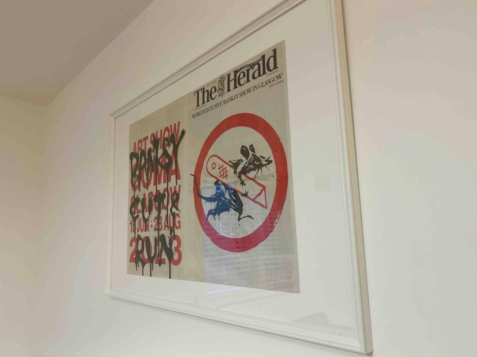 A framed poster with text and graphics, including a date and a red circle with a symbol.