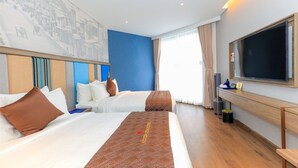Ein Hotelzimmer mit zwei Betten, einem großen Fernseher und einem Wandgemälde mit Stadtansicht.