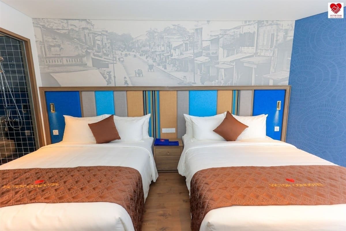 A hotel room with two beds, a shower area, and a mural of a street scene on the wall.