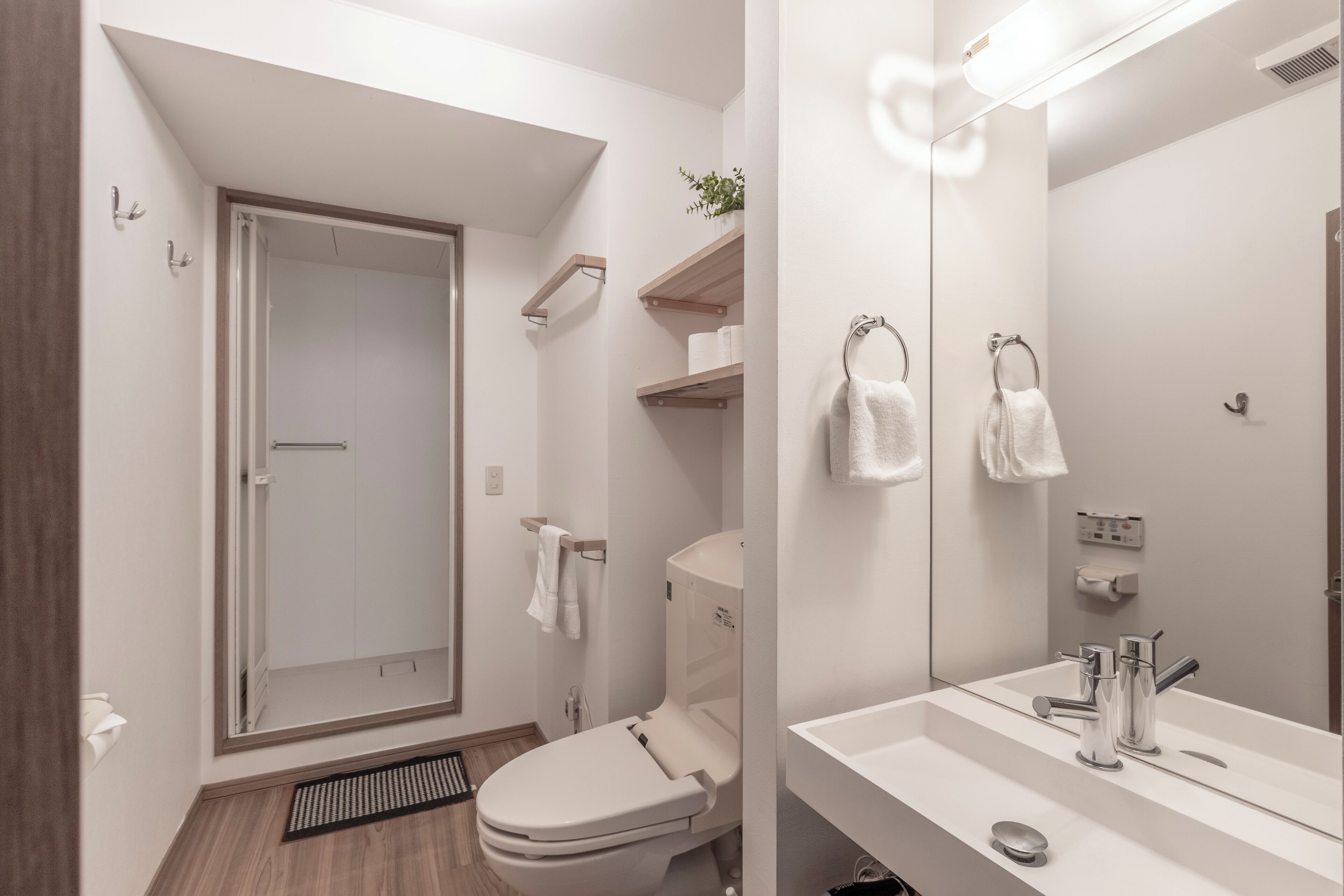 A modern bathroom with a shower, toilet, and sink.
