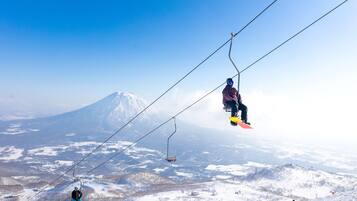 Eine Seilbahn vor einer verschneiten Berglandschaft.