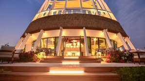 A modern building with a circular structure, large glass windows, and a thatched roof. - Tawila Island Resort (Hurghada)