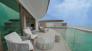 A deck with outdoor seating, a glass table, and a view of the ocean. - Tawila Island Resort (Hurghada)