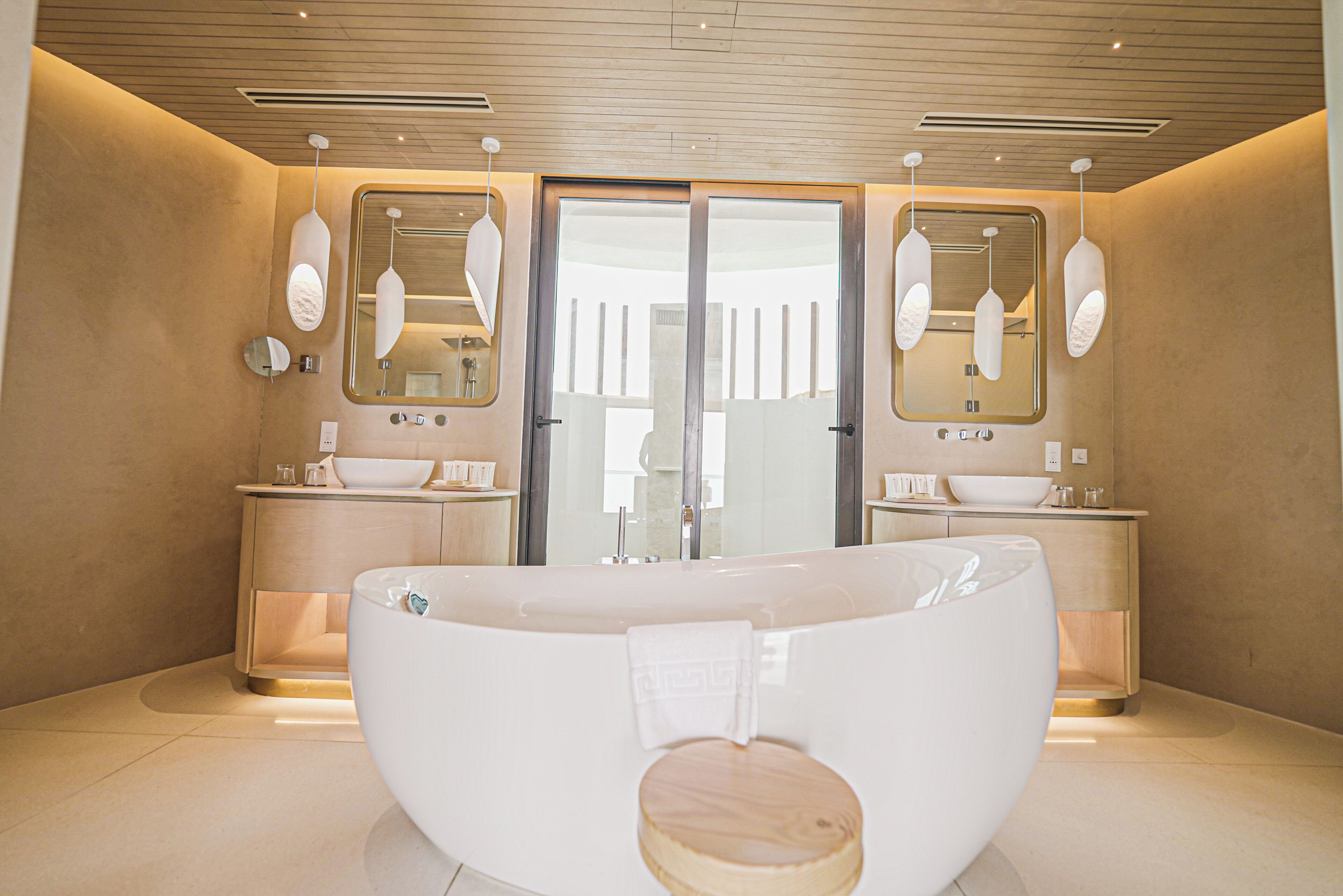 Un bagno moderno con una vasca freestanding ampia, due lavabi e un grande specchio.