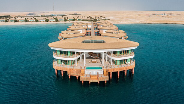 A floating hotel with multiple levels, a central pool, and a view of the surrounding desert and water. - Tawila Island Resort (Hurghada)
