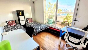 Una habitación de hotel pequeña con una cama, un escritorio y una silla.