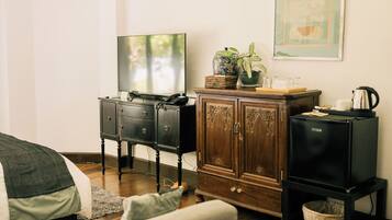 A living room with a sofa, a TV, a cabinet, and a framed picture on the wall.