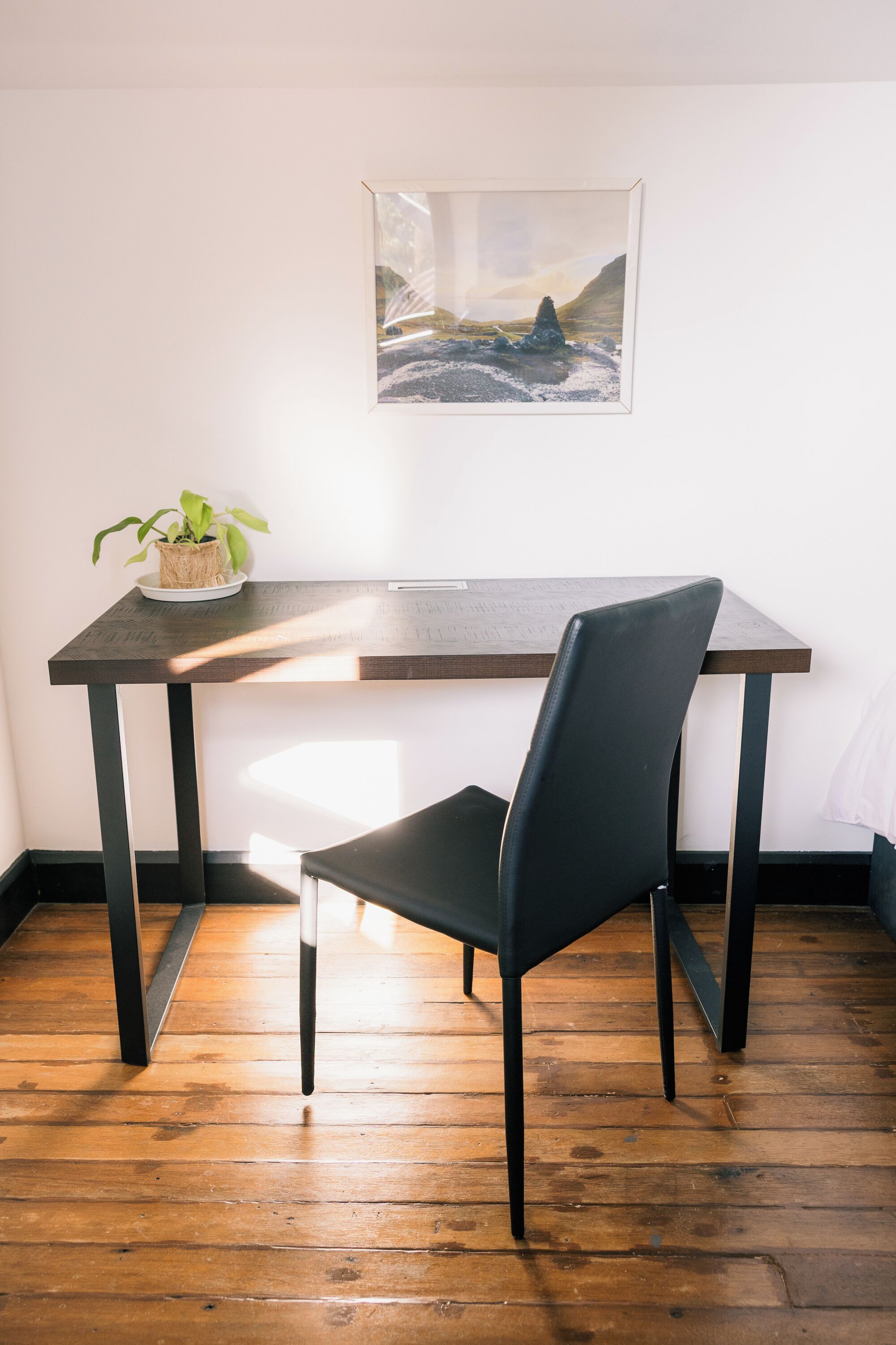 A dining area with a table, chair, and a framed picture on the wall.
