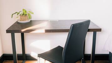 A dining area with a table, chair, and a framed picture on the wall.