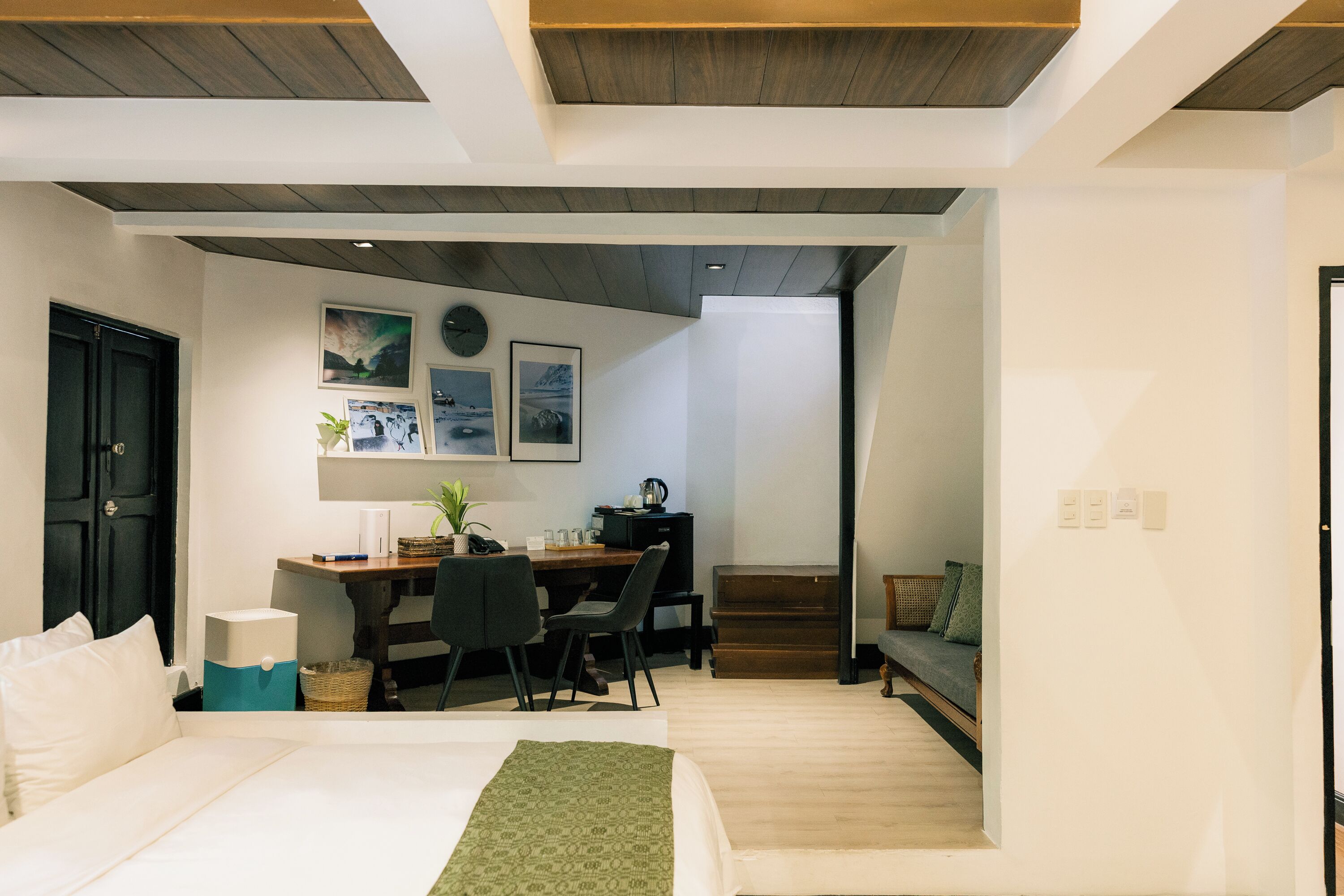 Une chambre moderne comprenant un lit, un bureau et un coin salon.
