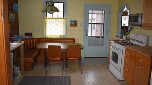 Une cuisine de taille réduite comprenant un coin repas, une cuisinière et un réfrigérateur.