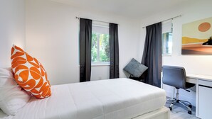 A bedroom with a bed, a desk, and a chair. - Spacious + Serene Miami Home: Walk to Metrorail! (Miami)