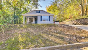 A single-story house with a front porch, a garage, and a stone retaining wall. - Centrally Located Home ~ Steps to Oxford Square! (Oxford)