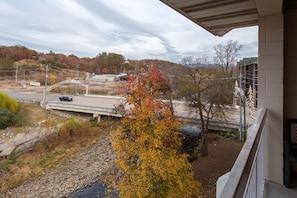 A view from a balcony overlooking a bridge, a road, and a hilly landscape with autumn foliage. - Downtown, Riverfront PigeonForge (Pigeon Forge)
