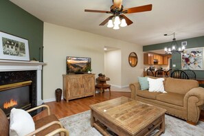 A living room with a fireplace, a ceiling fan, and a sofa. - Downtown, Riverfront PigeonForge (Pigeon Forge)