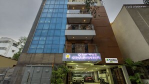 Un edificio de varios pisos con fachada de vidrio moderna y el letrero de Hiland Suites.