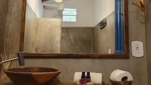 A bathroom with a large mirror, wooden beams, a sink with a bowl, and a towel holder. - Pousada Vilarejo (Porto Seguro)