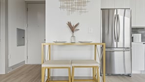 Enjoy cooking in this well-equipped kitchen with a refrigerator, table, and comfortable chairs.