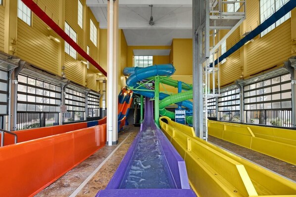 Een overdekt waterpark met meerdere glijbanen en een centrale glijbaan.