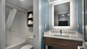 Ein modernes Badezimmer mit Badewanne, Toilette und Waschtisch mit Spiegel.