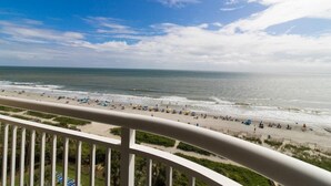 A beach view from a balcony with a railing, ocean, and clear sky. - Luxury Meets Coastal Living: 7th Floor Suite (Myrtle Beach)