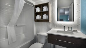 Et moderne badeværelse med bruser, toilet og vaskemøbel.