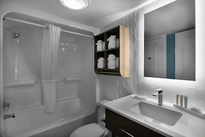 Ein modernes Badezimmer mit Badewanne, Toilette und Waschtisch mit Spiegel.