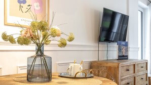 Et spisebord med en blomstervase, to hvide kopper og et fad med glas.
