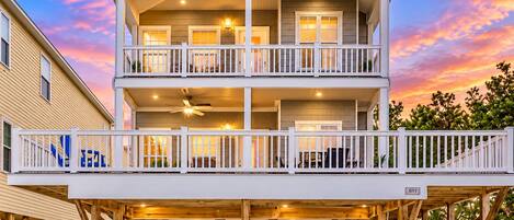 A two-story house with a balcony, a garage, and a covered deck area.