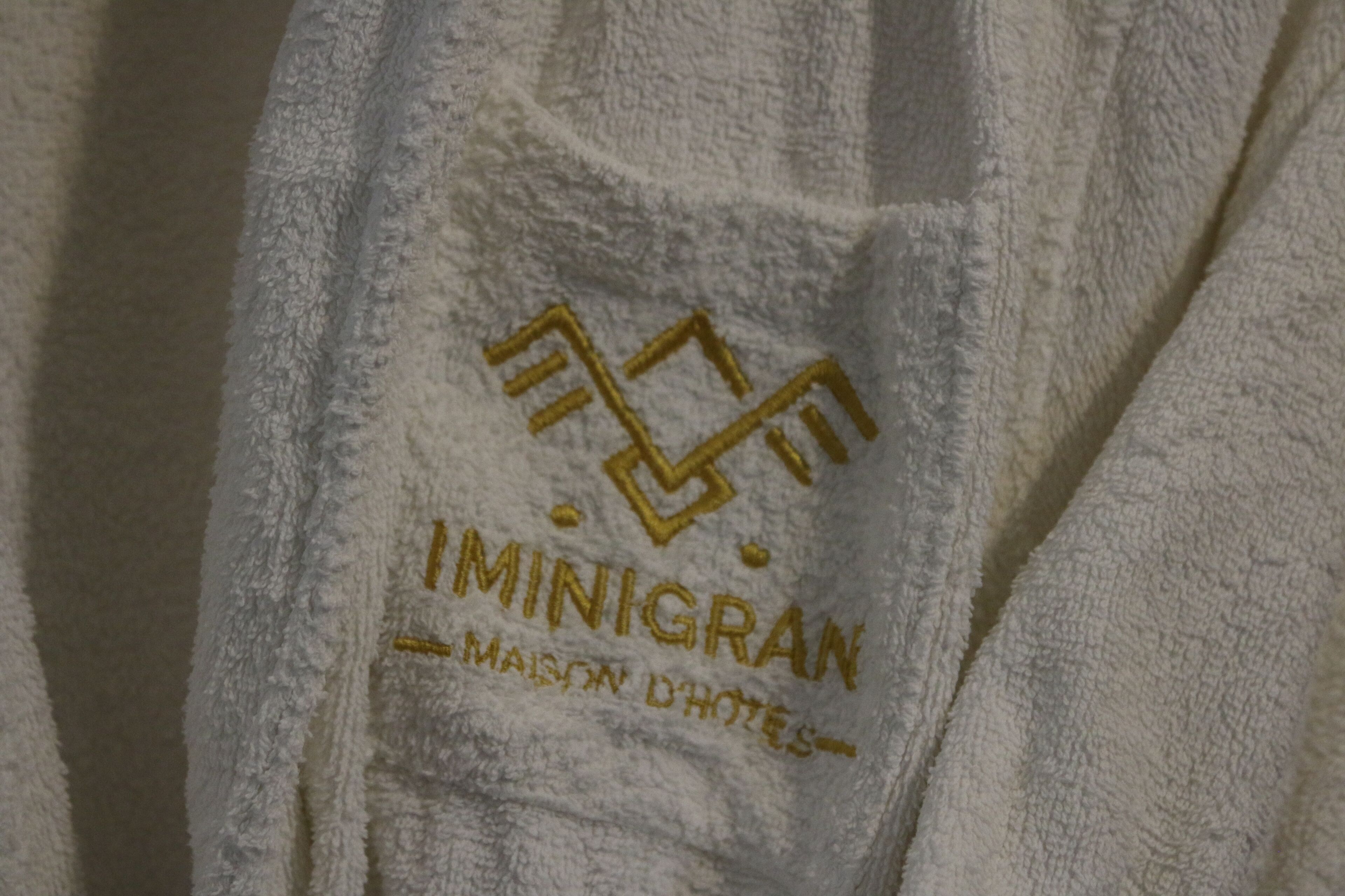 Una toalla blanca con texto bordado y un logotipo.